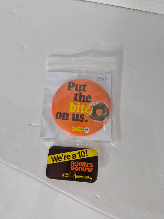 Vintage 1980s Robin’s Donuts Advertising Pinback Buttons – “Put the Bite on Us” & 10th Anniversary – Set of 2